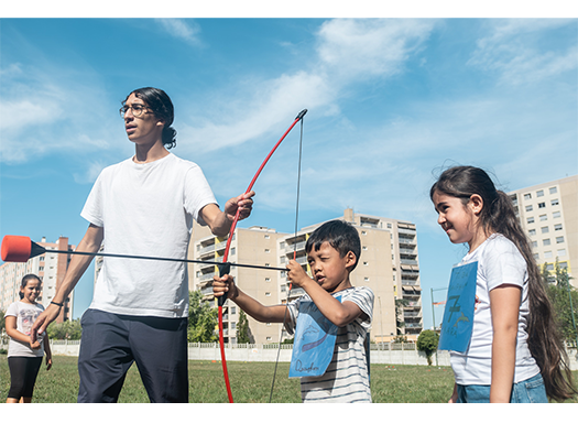 Une photo représentant des enfants et leur animateur faisant du tir à l'arc