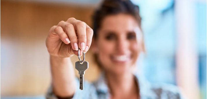 Jeune femme avec clé appartement