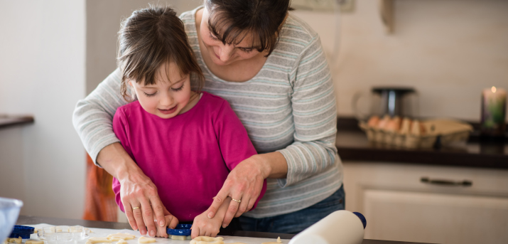 Personne aidant un enfant à faire un gâteau.