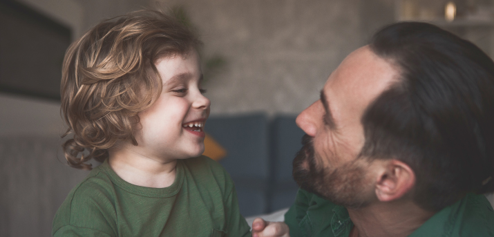 Un père et son enfant se sourient.