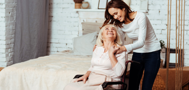 Femme aidant une femme en fauteuil