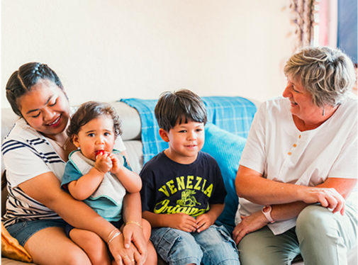 Une mère et ses deux enfants soutenus par un professionnel de l'accompagnement