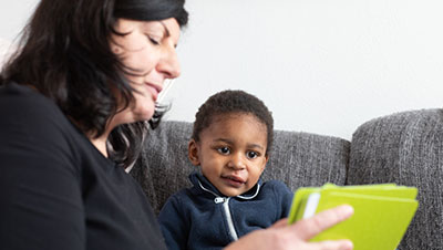 maman qui montre des photos souvenirs à son enfant adopté