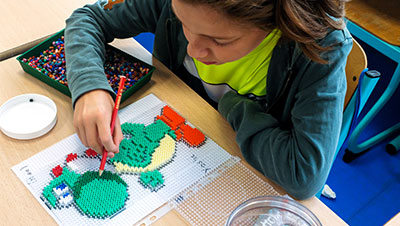 enfant pratiquant une activité manuelle créative