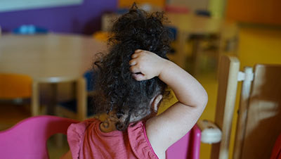 Un enfant qui se gratte la tête
