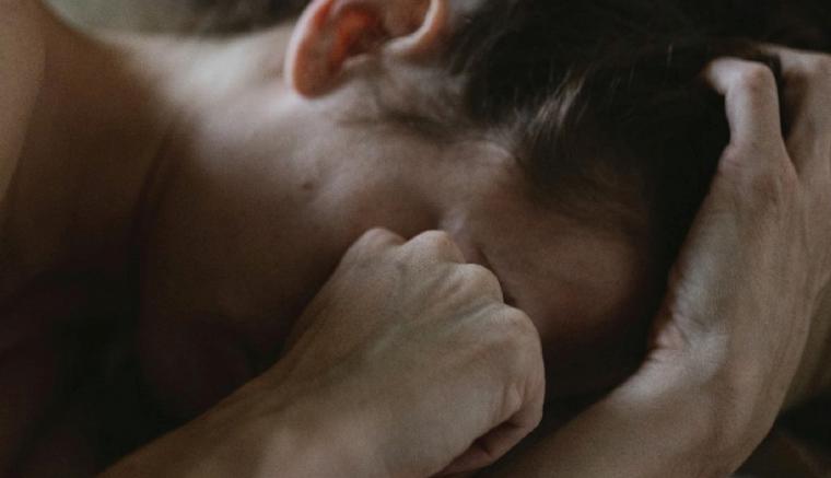 Une femme qui se cache le visage.